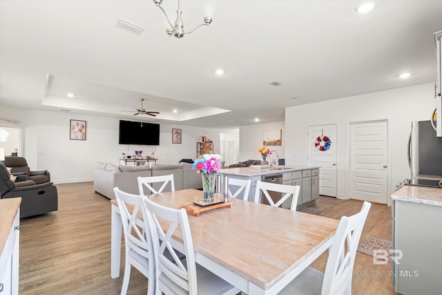 3973 Mercury Cir, Gulf Shores, AL 36542 - dining space with light wood-style floors, recessed lighting, a tray ceiling, and a ceiling fan
