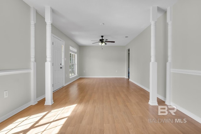 interior space with a ceiling fan, light wood-type flooring, and ornate columns