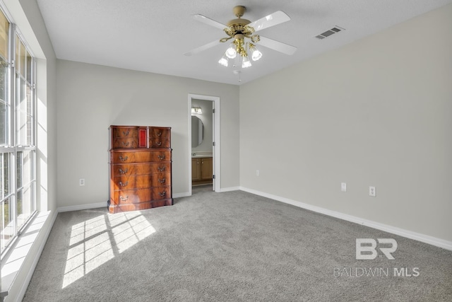 unfurnished bedroom with visible vents, multiple windows, carpet, and baseboards