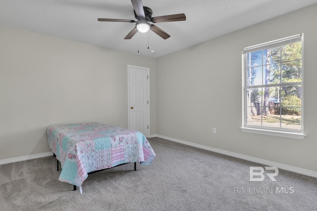 carpeted bedroom featuring baseboards and ceiling fan