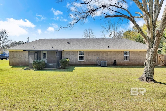 rear view of house featuring central air condition unit, a yard, brick siding, and fence