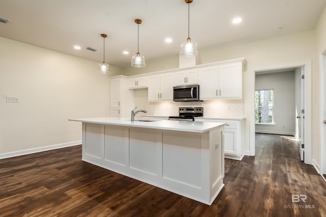 kitchen featuring white cabinetry, dark hardwood / wood-style flooring, an island with sink, and appliances with stainless steel finishes