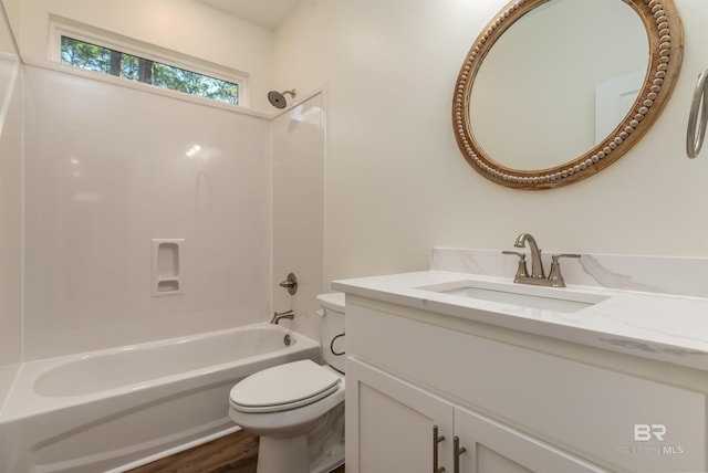 full bathroom featuring hardwood / wood-style floors, vanity, toilet, and tub / shower combination