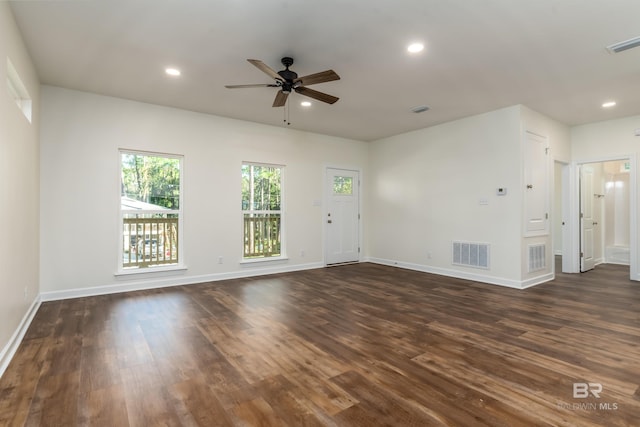 unfurnished living room featuring ceiling fan and dark wood-type flooring