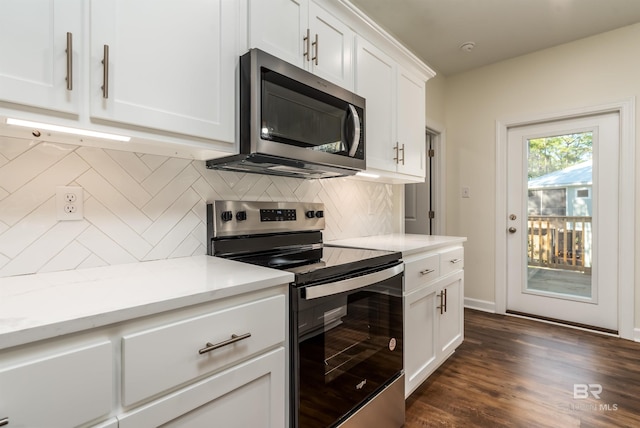 kitchen featuring white cabinetry, light stone countertops, dark wood-type flooring, decorative backsplash, and appliances with stainless steel finishes