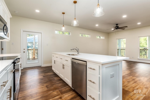 kitchen with hanging light fixtures, white cabinets, an island with sink, and appliances with stainless steel finishes