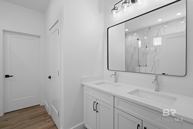 bathroom featuring vanity, wood-type flooring, and walk in shower