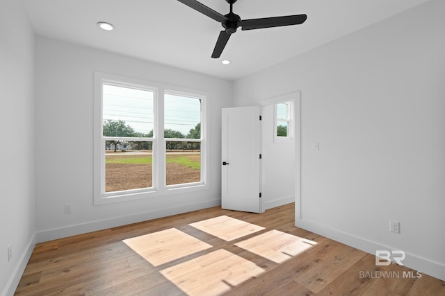 empty room with ceiling fan and light hardwood / wood-style floors