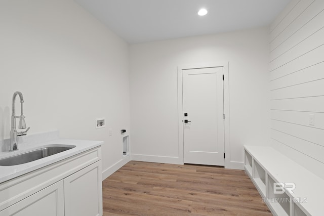 clothes washing area featuring sink, hookup for a washing machine, cabinets, hookup for an electric dryer, and light wood-type flooring