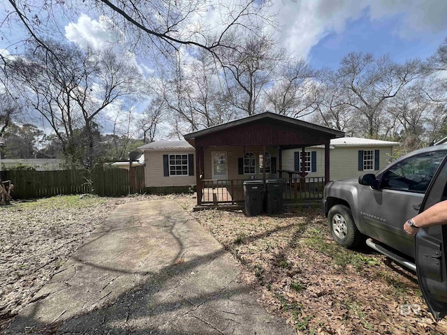 view of front facade featuring covered porch, metal roof, and fence