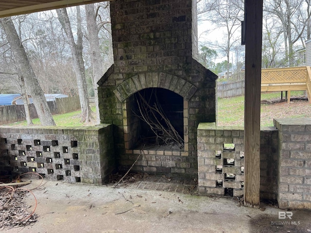 exterior space featuring an outdoor brick fireplace and fence