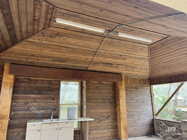 interior space featuring wood walls, a sink, and wood ceiling