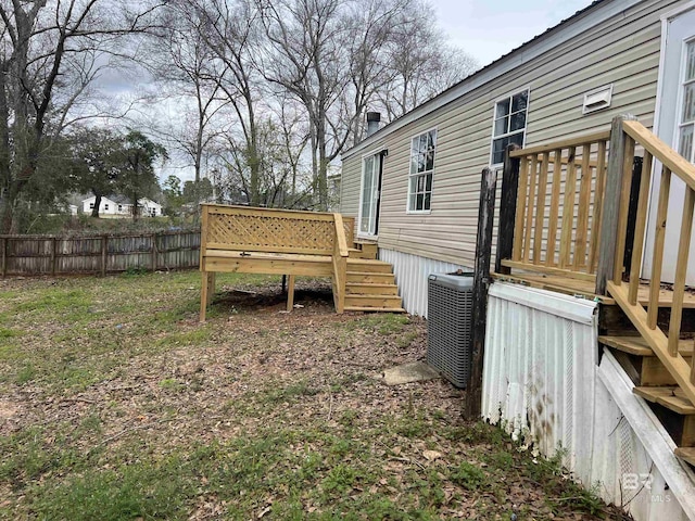 view of yard with fence, a deck, and central air condition unit