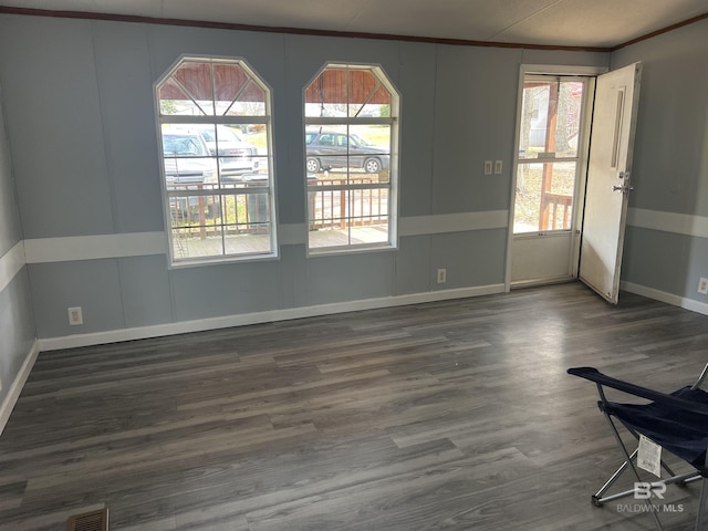 spare room featuring visible vents, plenty of natural light, and wood finished floors