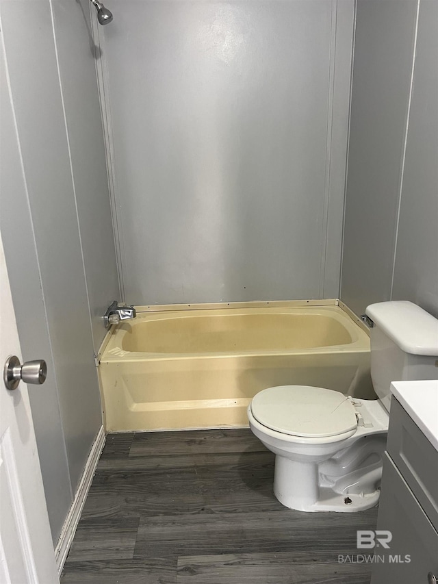 full bath featuring shower / bathtub combination, wood finished floors, vanity, and toilet