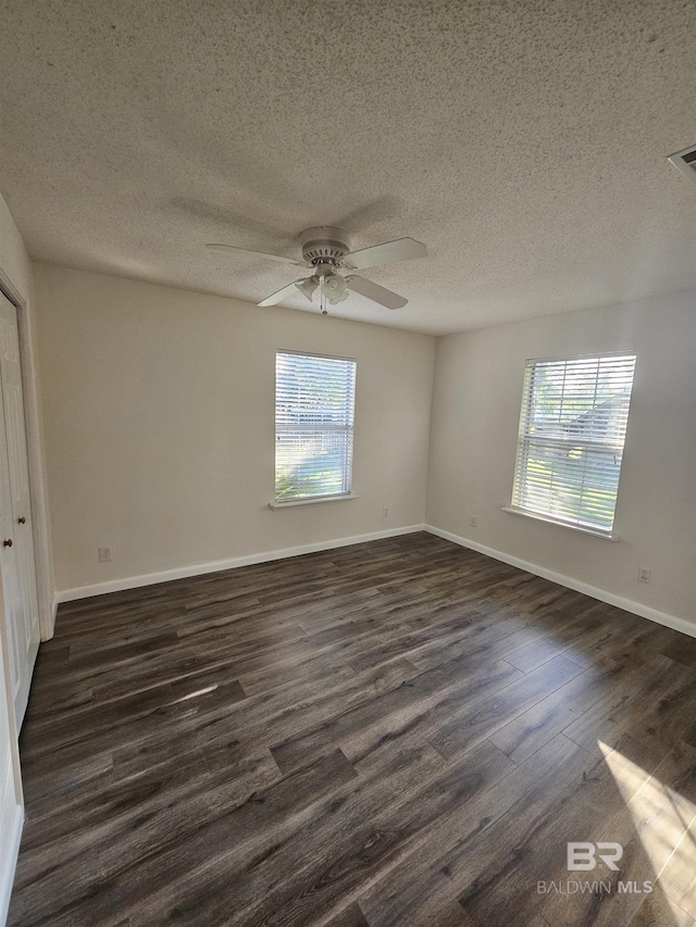 524 Linda Ln, Saraland, AL 36571 - unfurnished bedroom featuring dark wood-style floors, multiple windows, a textured ceiling, baseboards, and a ceiling fan
