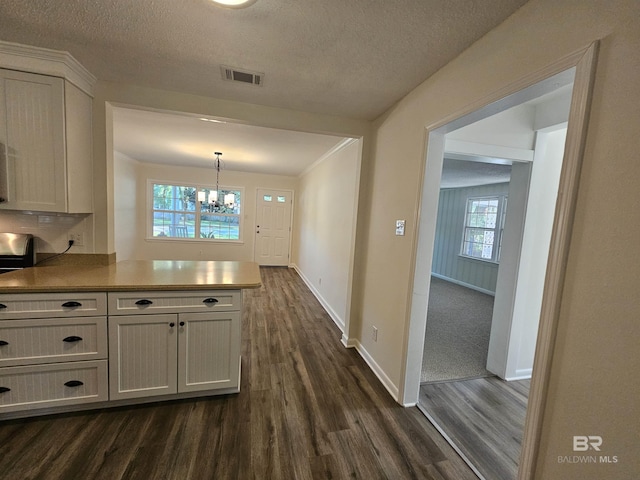 524 Linda Ln, Saraland, AL 36571 - kitchen with dark wood finished floors, a chandelier, a peninsula, baseboards, and a textured ceiling