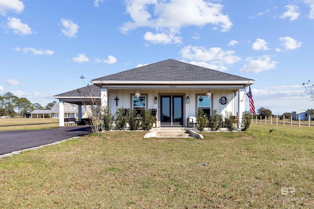 bungalow featuring driveway, covered porch, a front lawn, and an attached carport