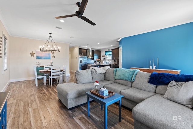 living area featuring baseboards, visible vents, wood finished floors, crown molding, and recessed lighting