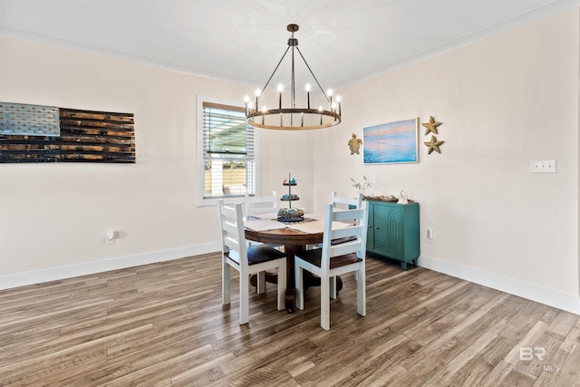 dining room featuring an inviting chandelier, baseboards, and wood finished floors