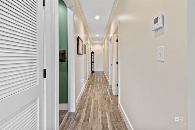 hall with baseboards, wood finished floors, and recessed lighting