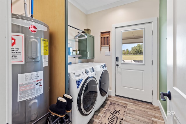 clothes washing area featuring laundry area, light wood finished floors, electric water heater, crown molding, and separate washer and dryer