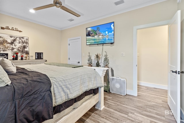 bedroom with a ceiling fan, wood finished floors, visible vents, and baseboards