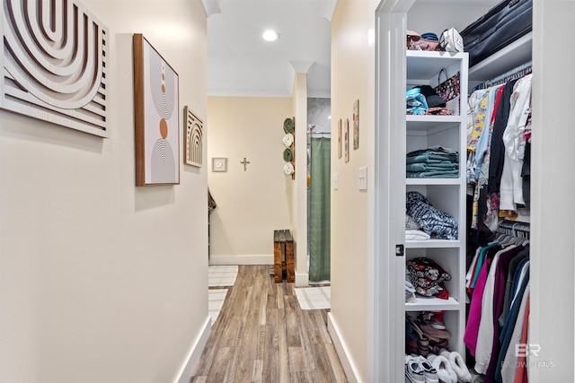 corridor with baseboards and light wood-style floors