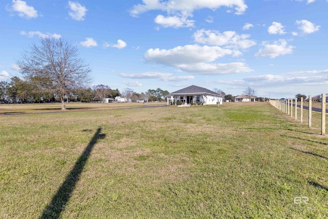 view of yard featuring a rural view and fence