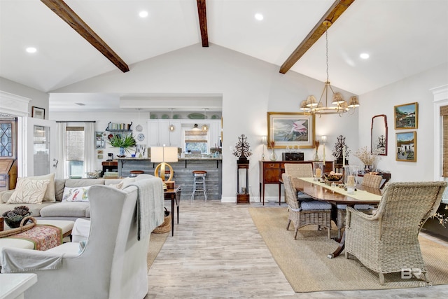 dining area featuring high vaulted ceiling, a notable chandelier, beam ceiling, and light hardwood / wood-style floors