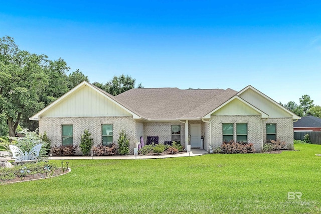 ranch-style house featuring a front yard, brick siding, and roof with shingles