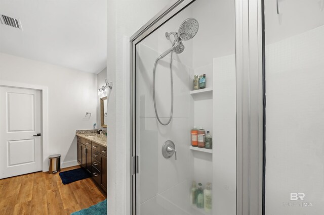 bathroom featuring visible vents, walk in shower, vanity, and wood finished floors