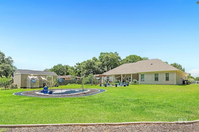 view of yard with central AC unit, fence, a patio, and an outdoor structure