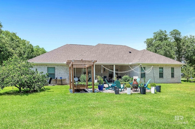 back of house with a lawn, roof with shingles, a patio area, a pergola, and brick siding