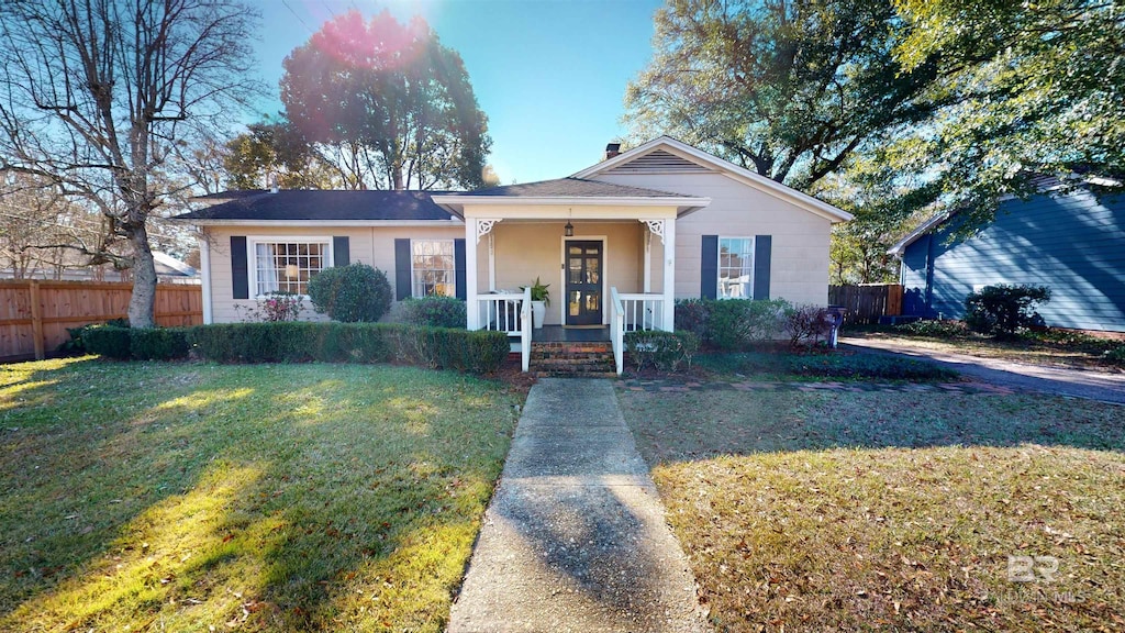 bungalow-style house featuring covered porch and a front yard