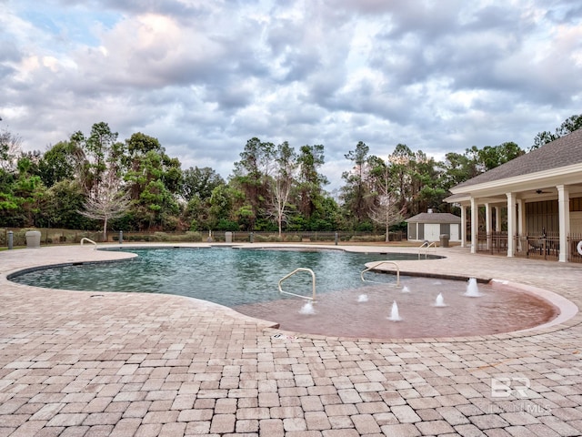 view of pool with a patio and pool water feature