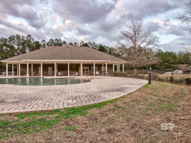 rear view of property with a fenced in pool and a patio area