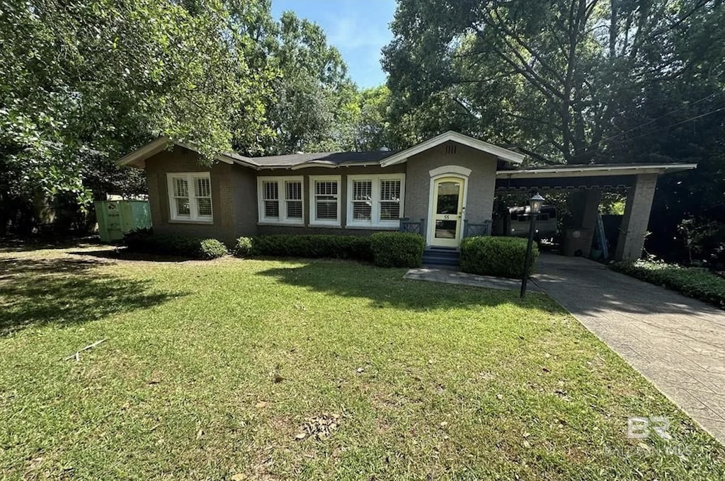 view of front facade featuring a front yard, a carport, driveway, and stucco siding