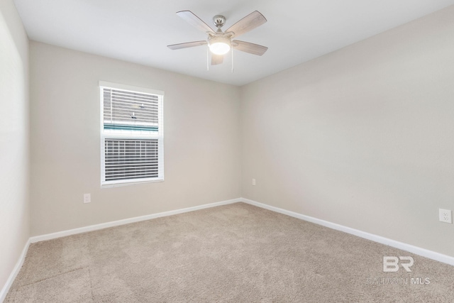 carpeted empty room featuring baseboards and a ceiling fan