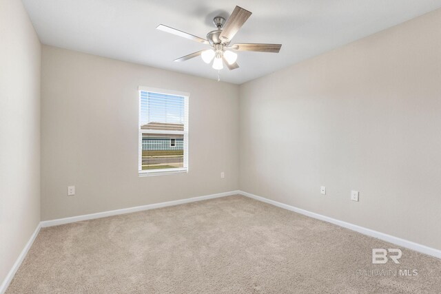 spare room with ceiling fan, carpet, and baseboards