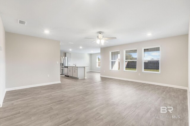 unfurnished living room with ceiling fan, recessed lighting, visible vents, baseboards, and light wood-style floors