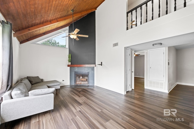 living room with ceiling fan, a tile fireplace, high vaulted ceiling, wooden ceiling, and beamed ceiling