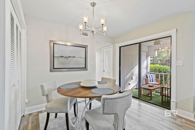 dining space featuring light hardwood / wood-style floors and an inviting chandelier