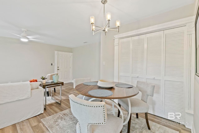 dining space featuring ceiling fan with notable chandelier and light wood-type flooring