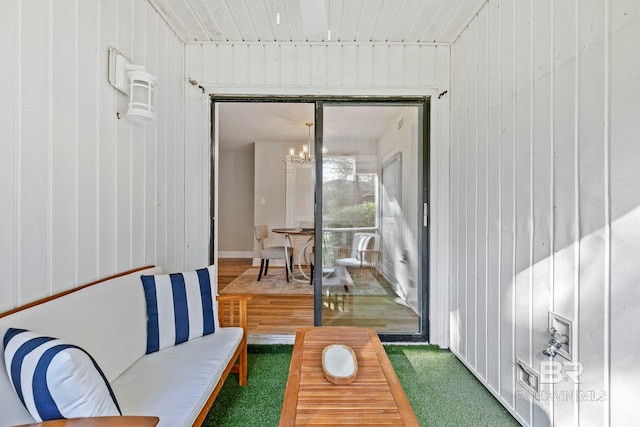 sunroom / solarium featuring an inviting chandelier