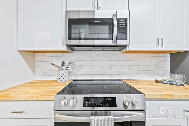 kitchen with tasteful backsplash, butcher block counters, stainless steel appliances, and white cabinets