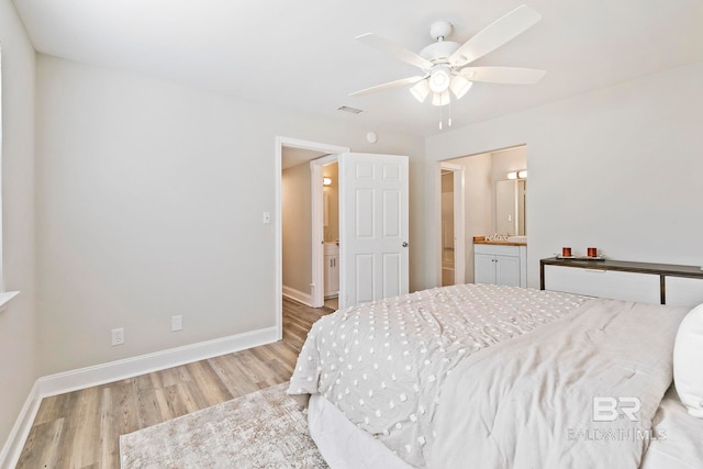 bedroom with ceiling fan, light wood-type flooring, and ensuite bath