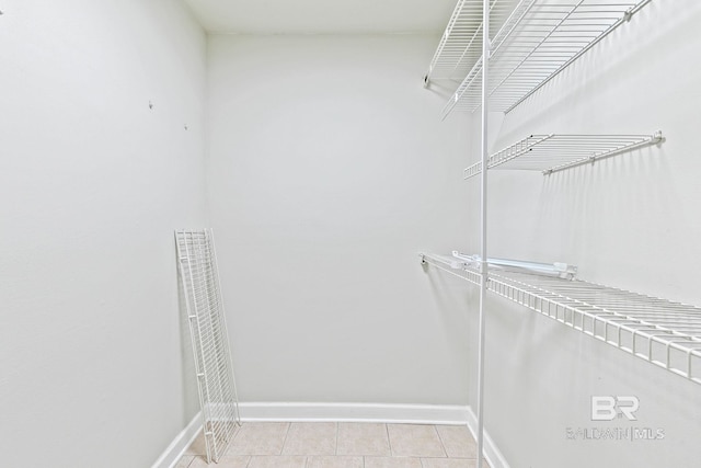 walk in closet with light tile patterned floors