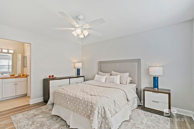 bedroom featuring ensuite bath, light wood-type flooring, and ceiling fan