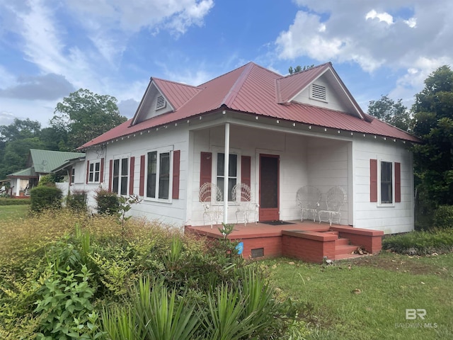 view of side of property with metal roof and a porch